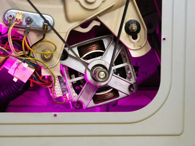 Washing machine opened up, showing the motor and drive belt